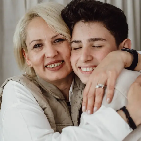 Parent embracing their transgender teen, symbolizing family support in gender-affirming therapy.